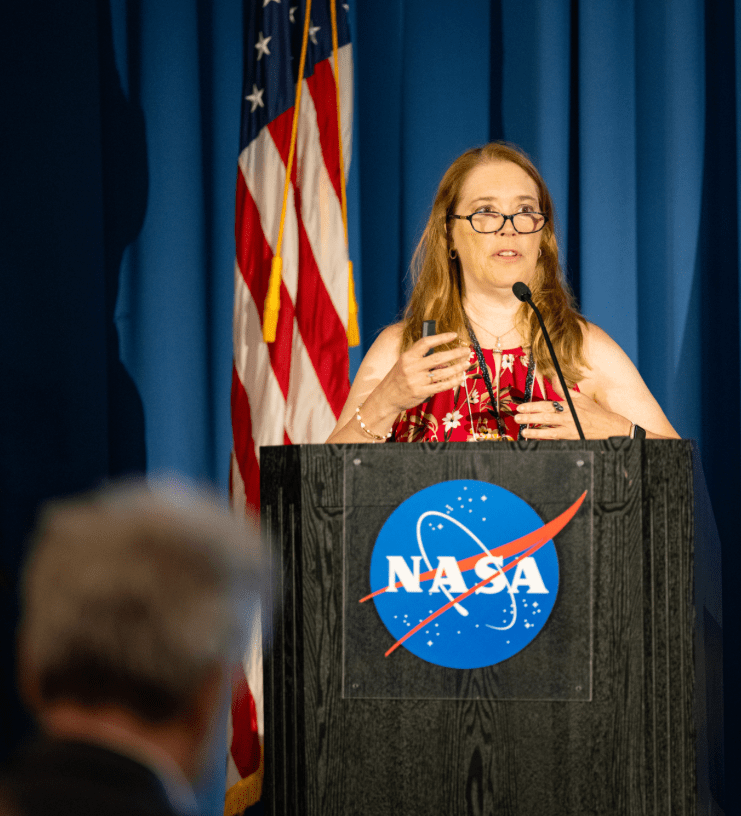 NASA Conjunction Assessment Program Officer Lauri Newman speaks at the 2024 NASA SmallSat Learning from Experience, Achievements, and Resolution, Navigation LEARN forum in the ballroom of Building 3 at NASA Research Park.